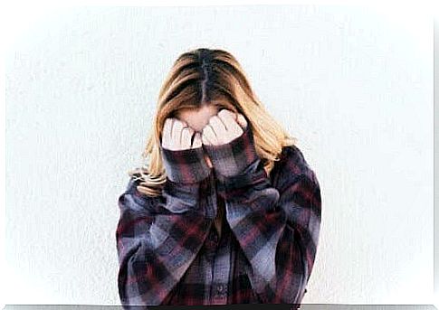 Girl feeling ashamed and covering her face.