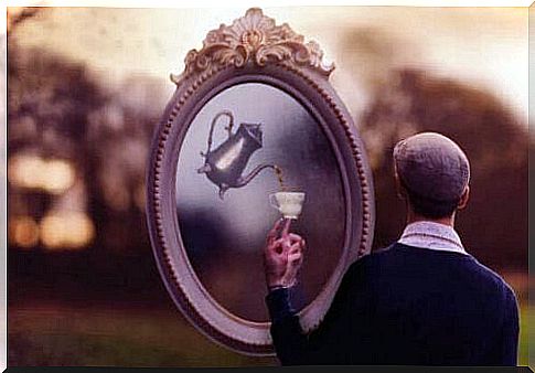 Man in front of a mirror with a cup of tea