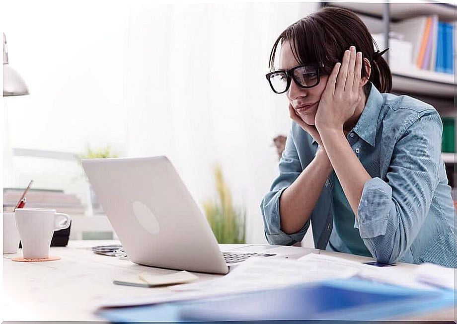 Woman looks at the computer bored