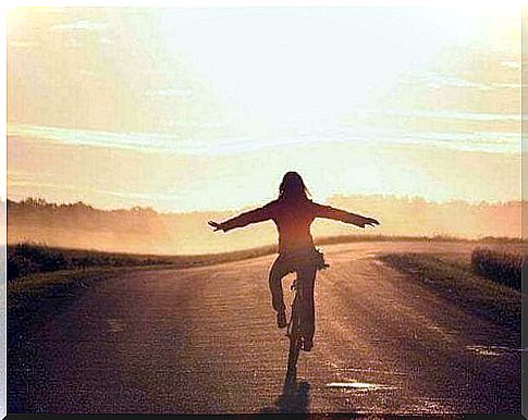 Woman on a bicycle while traveling a road, happy because she does not feel lost