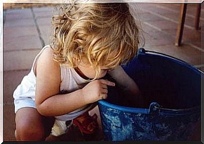 Little girl looking in the bucket