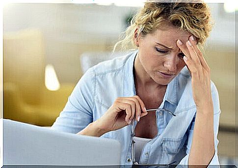 Woman with headache in front of computer