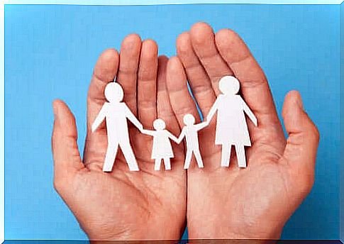 Hand holds family shape figures.