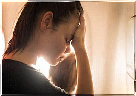 Woman with head in her hands afflicted with cognitive distortions.