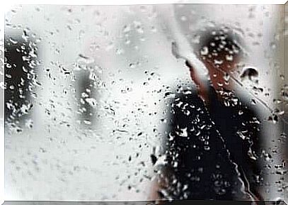 Silhouette of man behind a rain-soaked window.